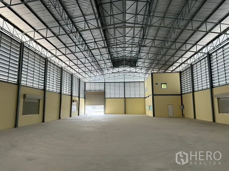 Warehouse for rent or sale in Bang Phli, Samut Prakan - Open storage hall featuring twin roller shutters, concrete floor and an internal office block.