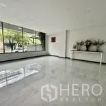 Home Office for rent in Wang Thonglang, Bangkok - Open reception area with large street-facing window and polished tile floor.