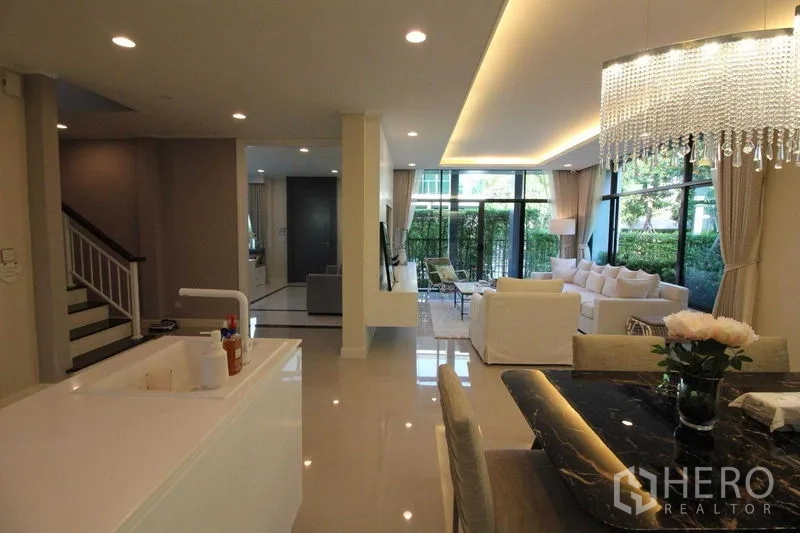 Detached House for rent in Prawet, Bangkok - Open-plan kitchen and dining area facing the garden through large windows.