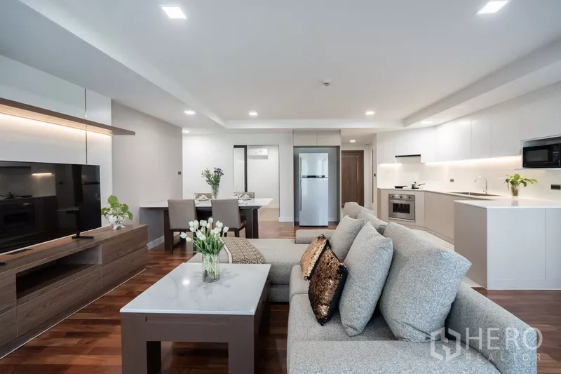 Apartment for rent - View from living room to dining table and sleek white kitchen.