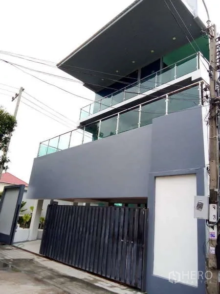 Detached House for sale in Lat Phrao, Bangkok - Street-side view of the three-storey modern home with balconies and gated entrance.