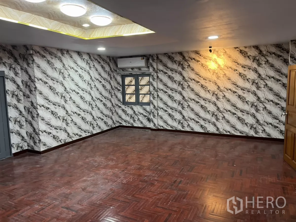 独立式住宅 出租在Watthana, Bangkok - 宽敞起居区，拼花地板、大理石纹墙纸与嵌灯。