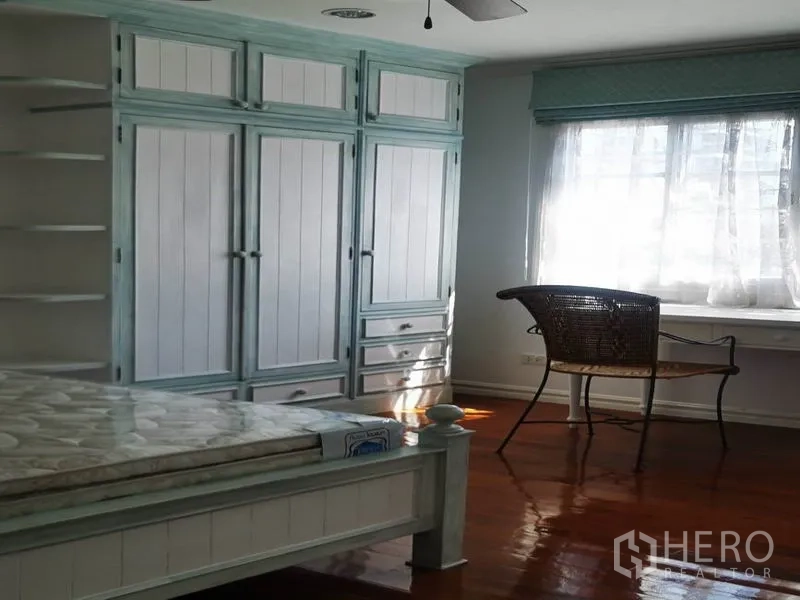 Detached House for rent in Mueang Samut Prakan, Samut Prakan - Bright bedroom with pastel blue built-in wardrobe, desk and sunlit window.