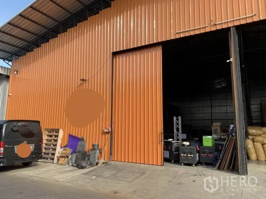 Warehouse for rent in Bang Kapi, Bangkok - Orange metal-clad warehouse exterior with a large sliding door and covered loading area in Bang Kapi.