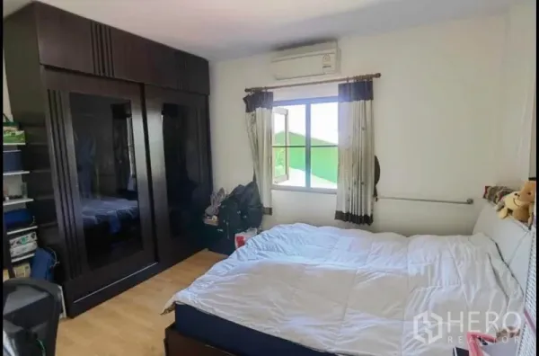 Detached House for sale in Bang Yai, Nonthaburi - Air-conditioned bedroom with large bed and dark built-in wardrobe.