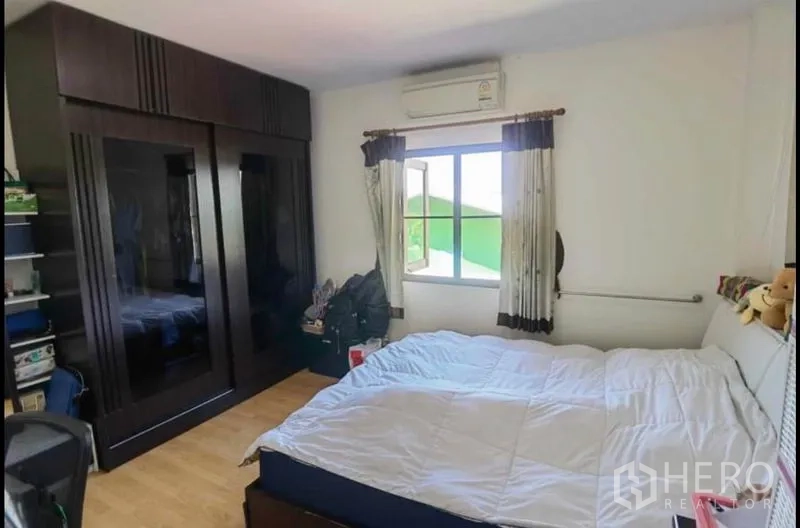 Detached House for sale in Bang Yai, Nonthaburi - Air-conditioned bedroom with large bed and dark built-in wardrobe.