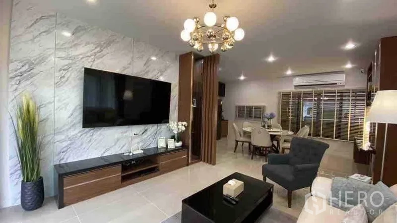 Detached House for rent or sale in Prawet, Bangkok - Marble feature wall with mounted TV and media console in a modern living room.