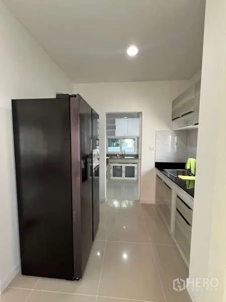 Detached House for rent in Bang Kapi, Bangkok - Galley kitchen with tall refrigerator and built‑in cabinets.
