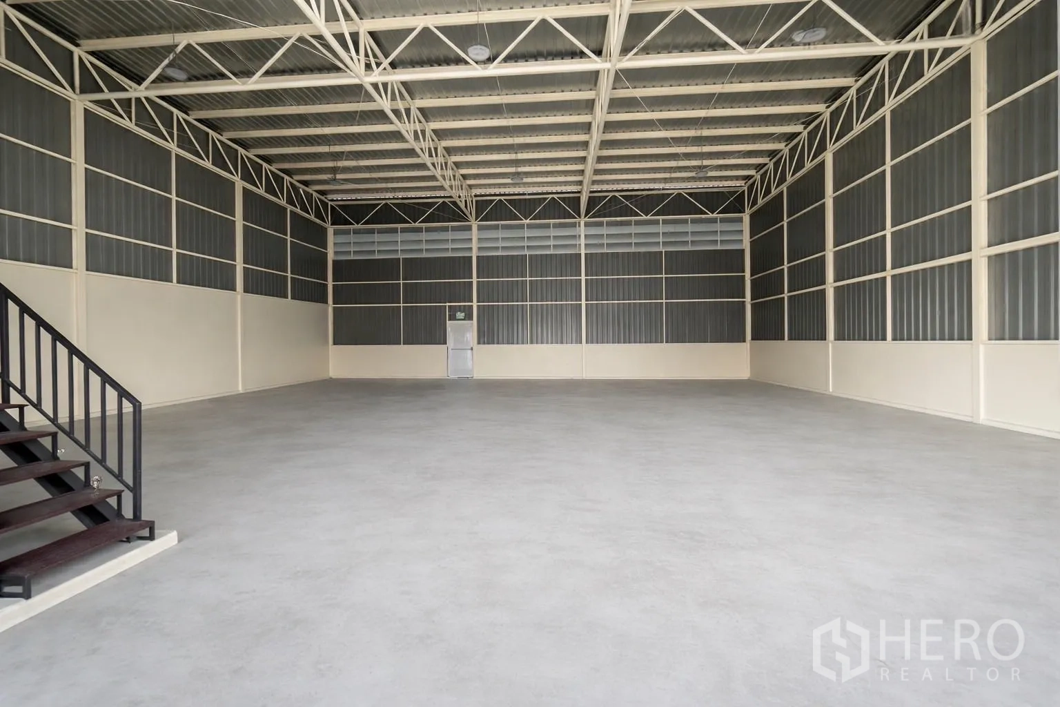Warehouse for rent in Prawet, Bangkok - Open warehouse interior with high ceiling, steel trusses and concrete floor.