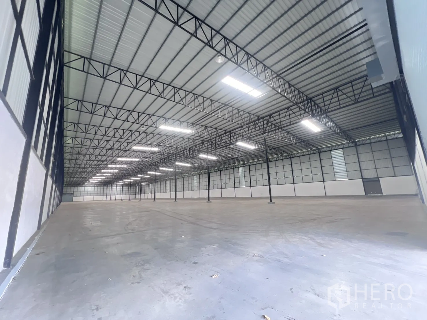 仓库 for rent in Mueang Samut Sakhon, Samut Sakhon - 仓库内部开阔，钢桁架屋顶与平整地面。