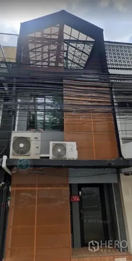 Home Office for sale in Bang Rak, Bangkok - Modern townhouse home office facade with a glass gable roof and exterior air-conditioning units.
