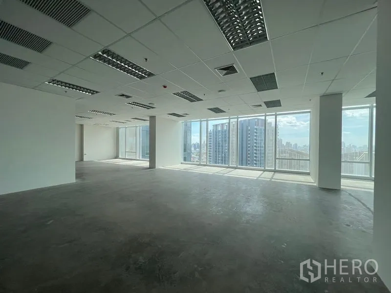 Office Space for rent - Open-plan high-floor office with floor-to-ceiling windows and Bangkok skyline views.
