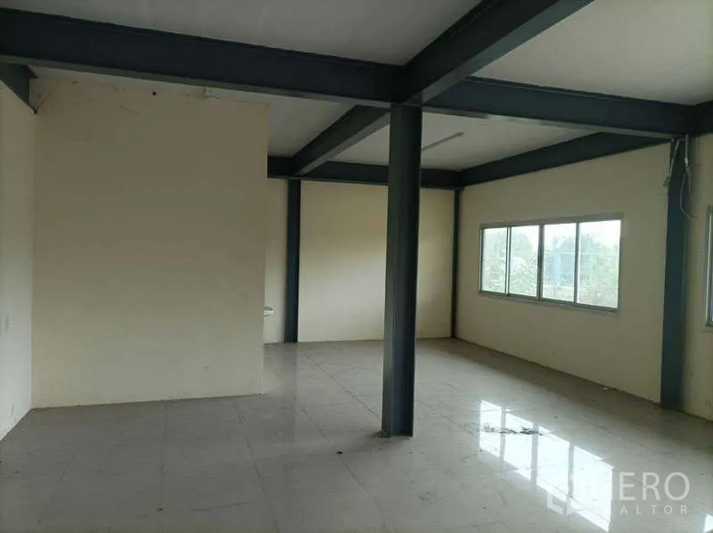 Factory for rent in Ban Phaeo, Samut Sakhon - Tiled mezzanine office room with steel beams and windows overlooking greenery.