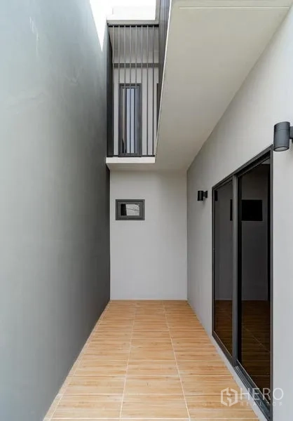 Detached House for sale in Lam Luk Ka, Pathum Thani - Side terrace with sliding doors and tiled floor.