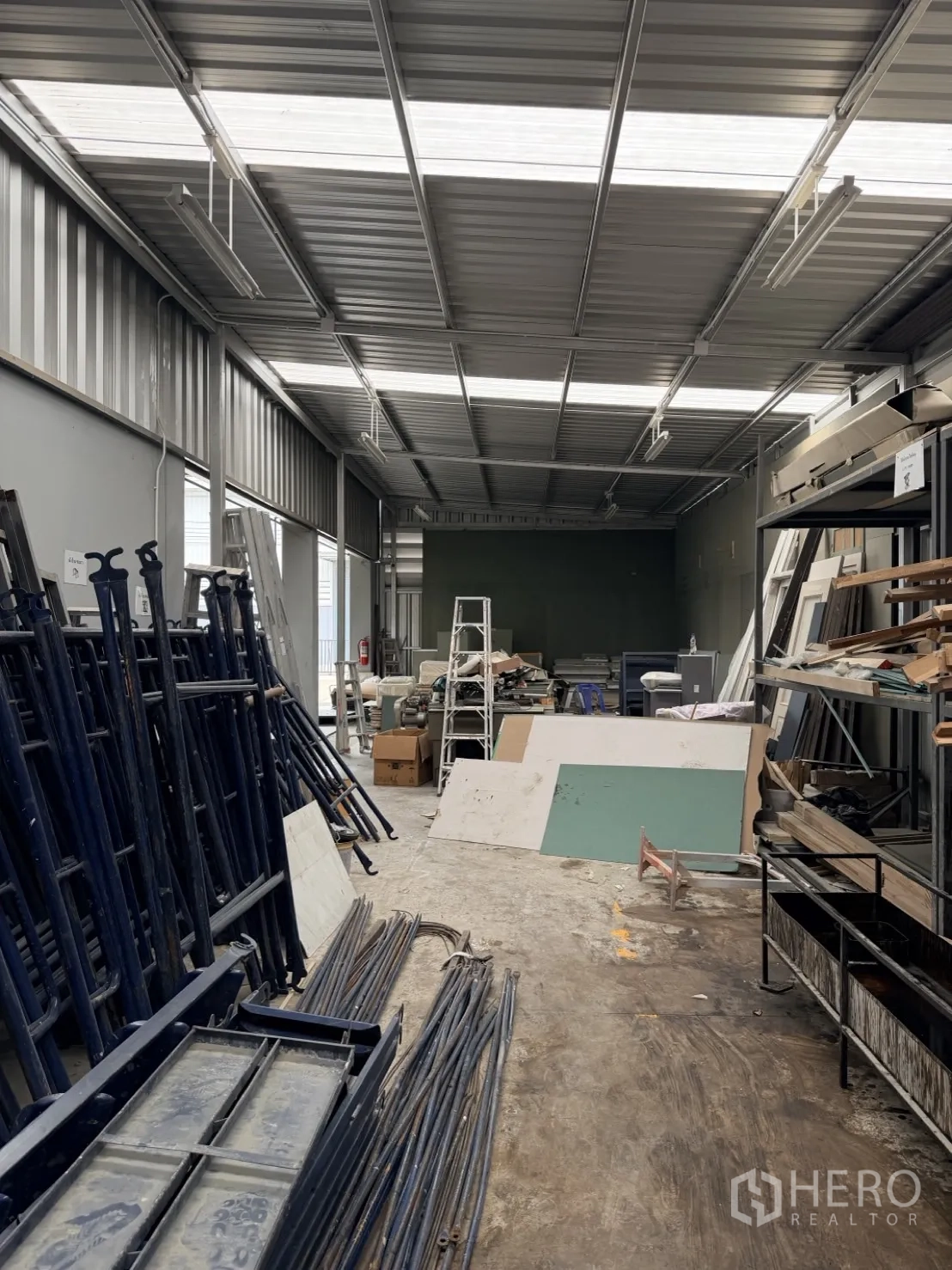 Factory for rent or sale in Lam Luk Ka, Pathum Thani - Covered side bay used for material and scaffold storage.