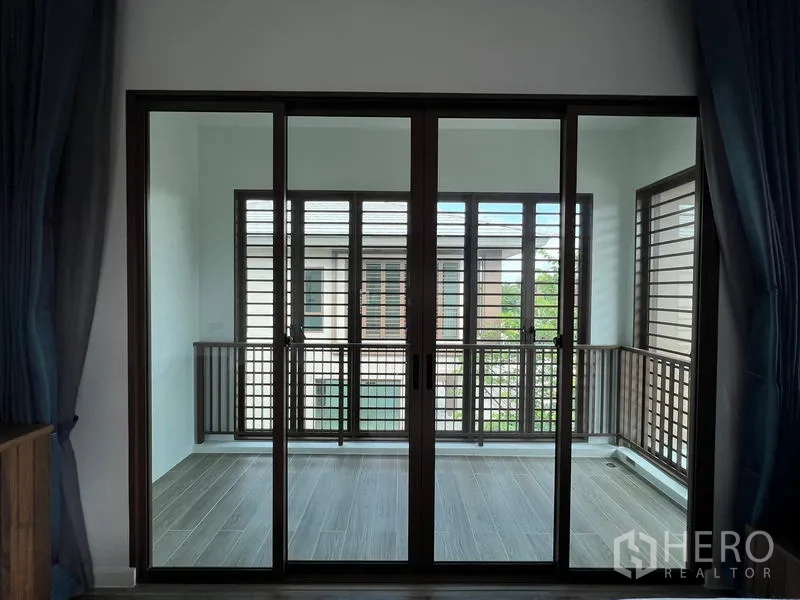 Detached House for rent in Bang Kapi, Bangkok - Enclosed balcony or sunroom with sliding glass and wooden louver screens.