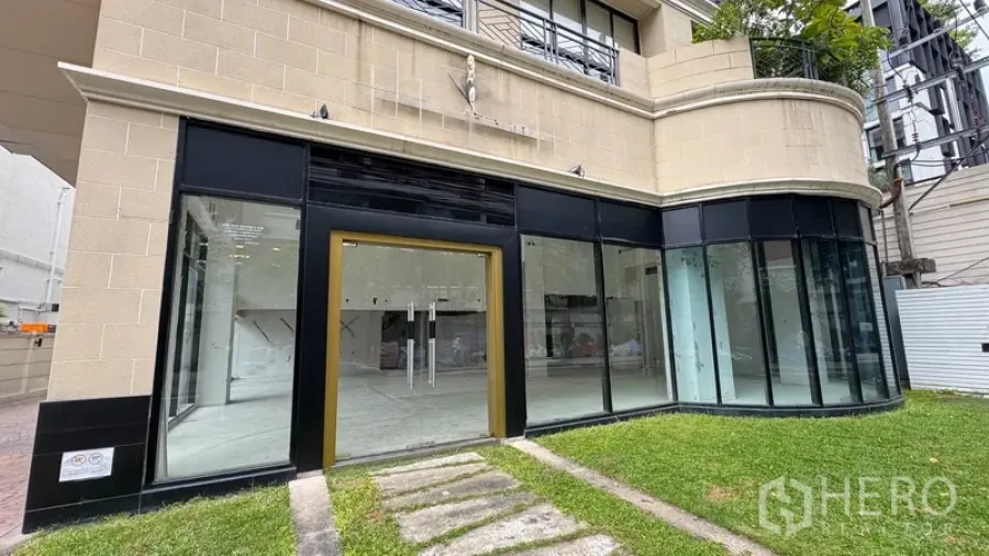 Retail Space for rent in Watthana, Bangkok - Street-facing shopfront with gold-trimmed glass entrance and grass path.