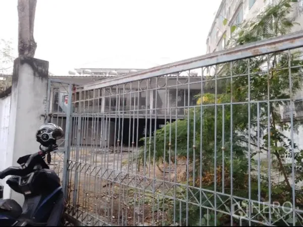 Warehouse for rent or sale in Bang Kho Laem, Bangkok - Gated entrance with metal fence and a motorcycle in front of a two-storey warehouse yard.