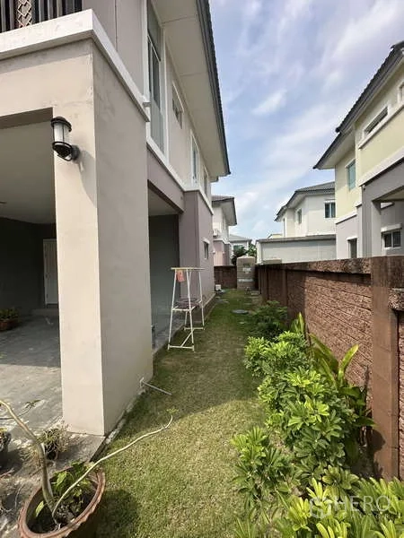 独立式住宅 出售在Sai Mai, Bangkok - 房屋侧面草坪花坛的狭长花园。