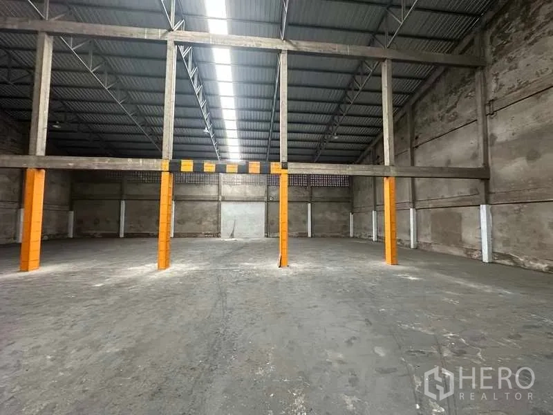 货栈 出租在Mueang Pathum Thani, Pathum Thani - 大跨距结构与安全标识立柱，适合货架或轻加工。