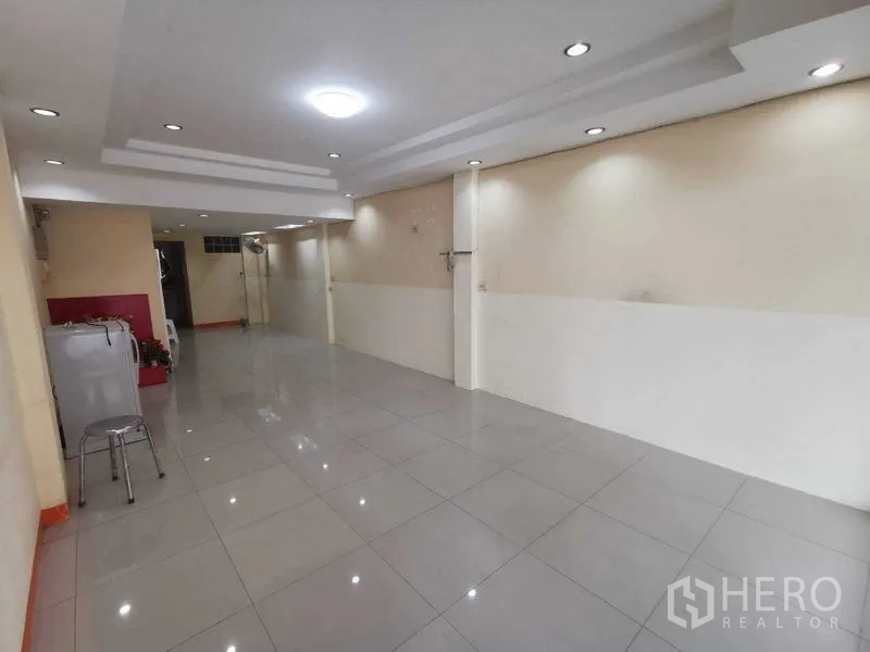 Shophouse for rent in Suan Luang, Bangkok - Long open-plan shop area with ceiling lights and display niche.
