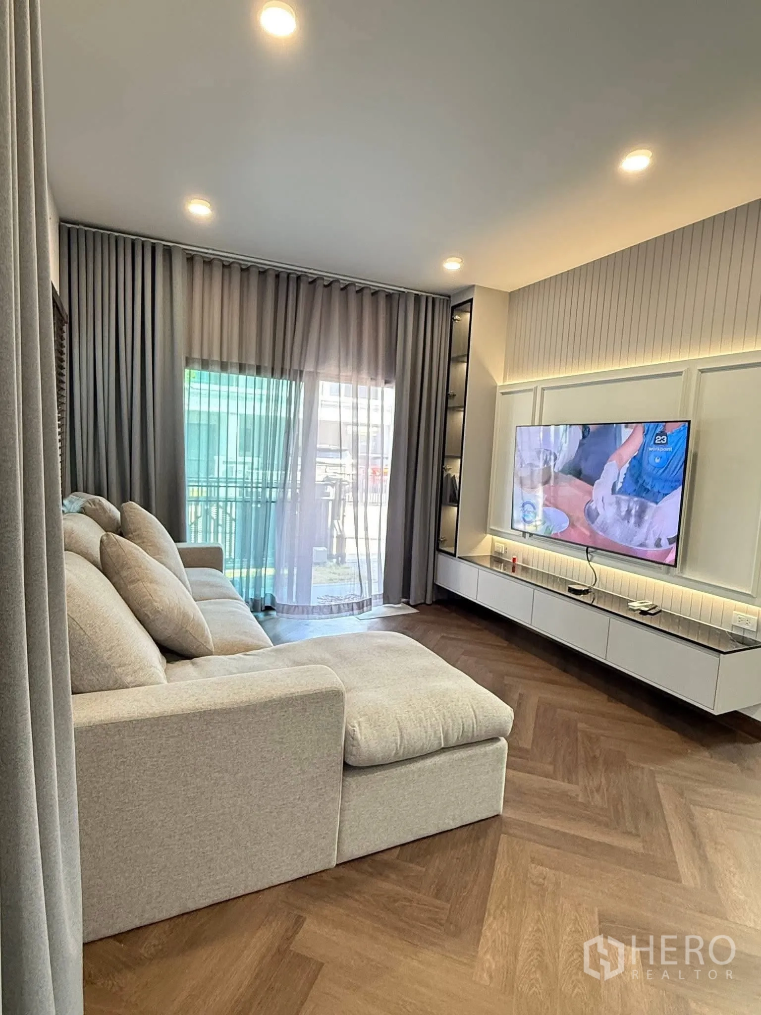 Detached House for rent in Bang Phli, Samut Prakan - Living room with L-shaped sofa, sliding glass door and sheer curtains.