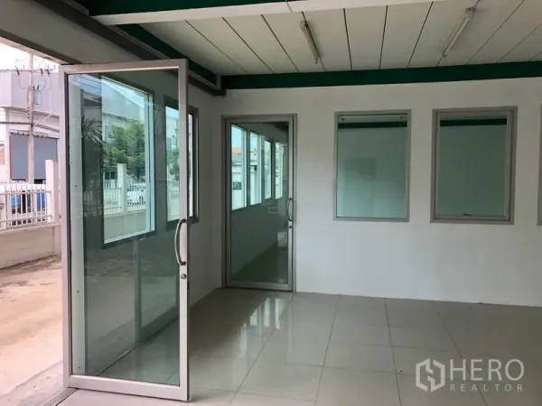 Factory for rent in Lam Luk Ka, Pathum Thani - Ground‑floor glass entry to the office area with sliding doors and tiled flooring.