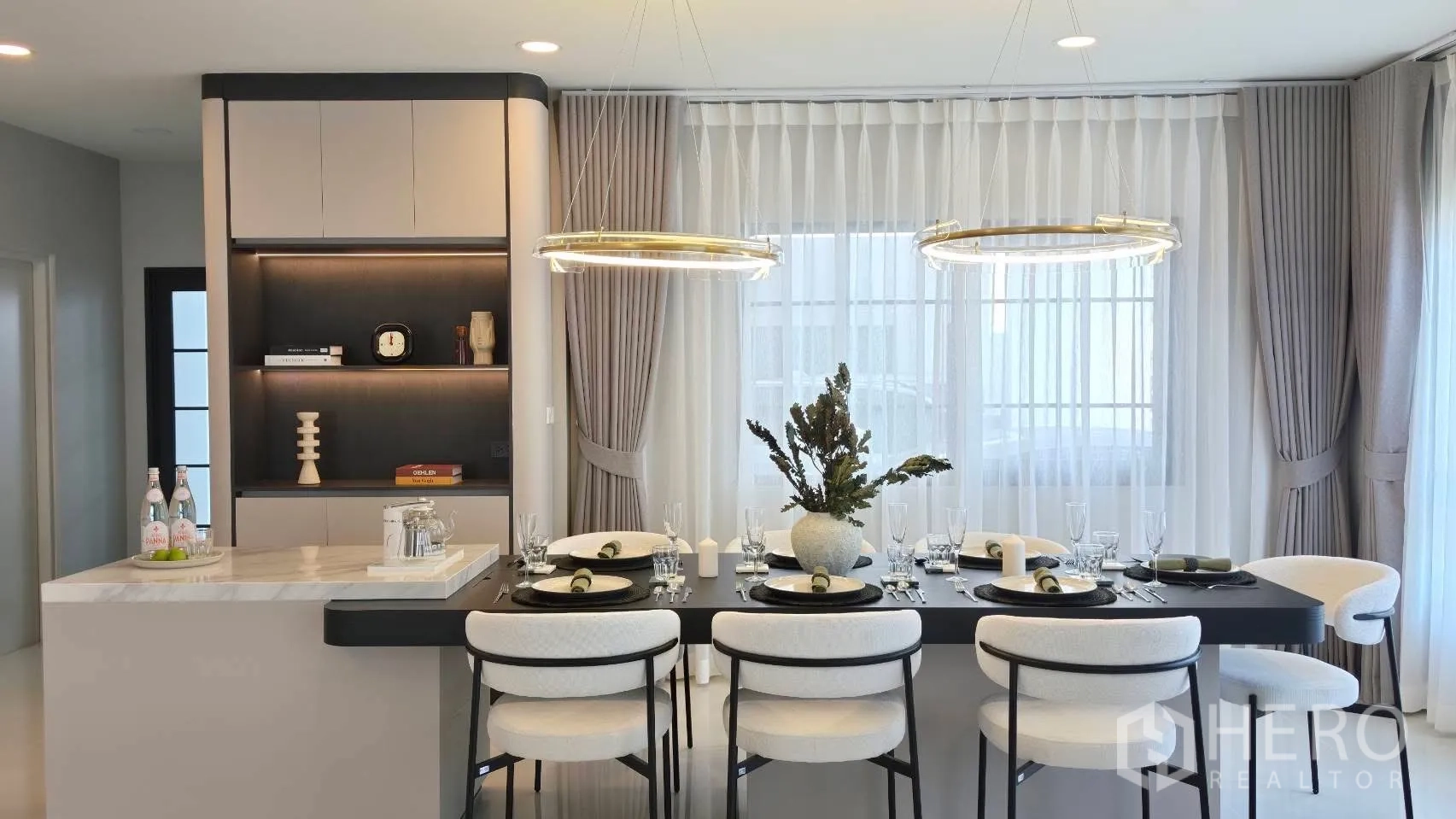 Detached House for rent in Bang Phli, Samut Prakan - Open-plan kitchen island beside long dining table and sheer curtains.
