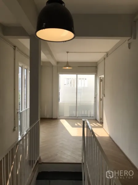 Detached House for rent or sale in Din Daeng, Bangkok - Bright upstairs landing with pendant lights, herringbone wood floor and sliding glass doors.