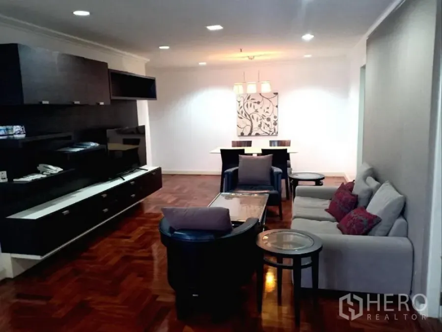 คอนโด ให้เช่าในWatthana, Bangkok - ห้องนั่งเล่นและรับประทานอาหารกว้าง พื้นไม้ปาร์เกต์ ผนังบิลท์อิน ชั้นวางทีวี โซฟา และโคมไฟแขวนในคอนโดกรุงเทพฯ