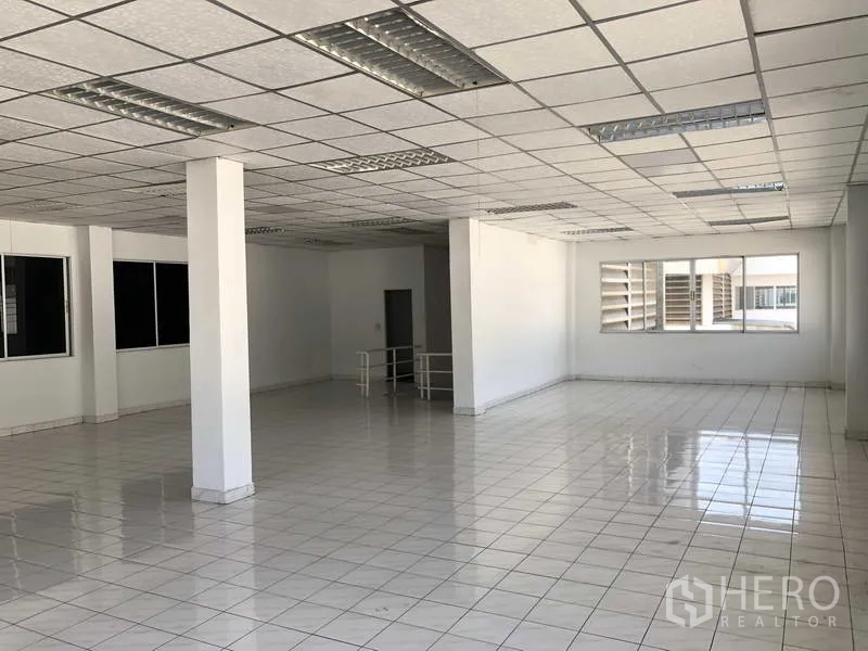 Warehouse for rent in Phra Nakhon Si Ayutthaya - Open‑plan office floor with glossy tiles, drop ceiling and multiple windows for natural light.