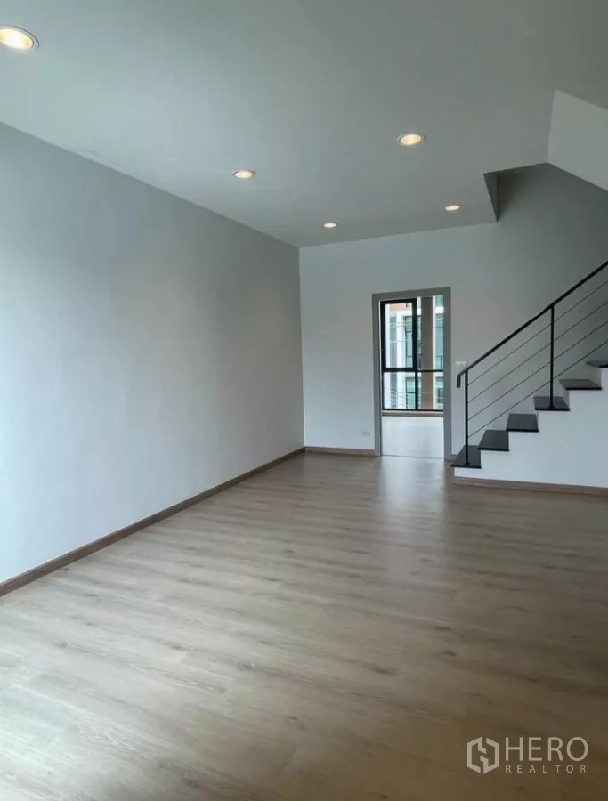 Home Office for rent in Bueng Kum, Bangkok - Spacious room with wood flooring and a minimalist metal staircase.