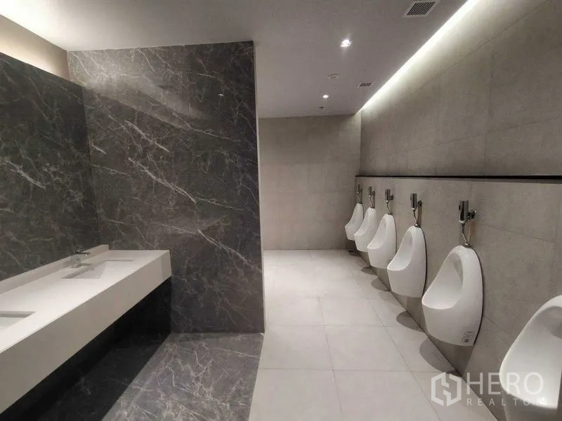 Office Space for rent in Phra Khanong, Bangkok - Men’s restroom with a row of urinals and marble-accented vanity.
