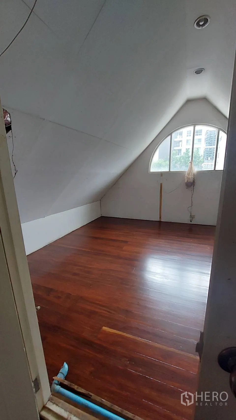 Office Space for rent in Watthana, Bangkok - Attic-style workspace viewed from the doorway, arched window, recessed lighting and glossy wood flooring.