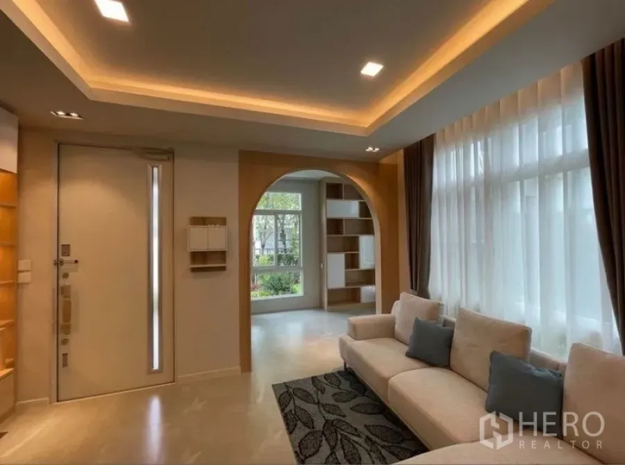 Detached House for rent in Prawet, Bangkok - Bright living room in a Prawet detached house with cove lighting, tall windows and an arched doorway.