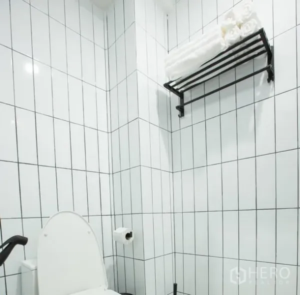 Townhouse for rent in Sathon, Bangkok - Clean bathroom finished with white vertical subway tiles and a wall-mounted towel rack.