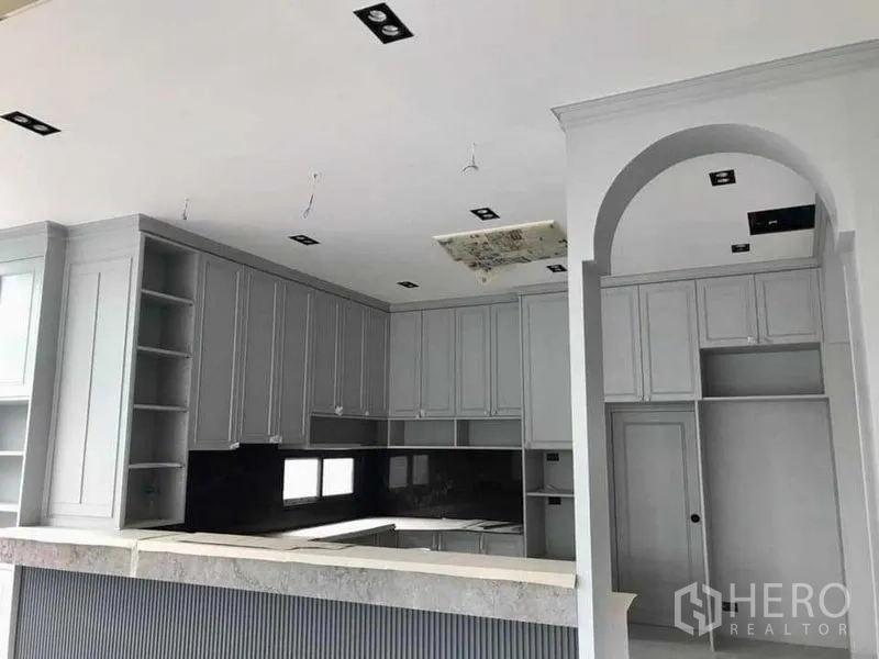 Detached House for sale in Mueang Nonthaburi, Nonthaburi - Close view of U‑shaped grey kitchen with arch detail and stone countertop.