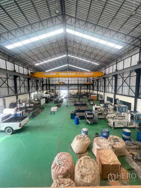 Factory for sale in Si Racha, Chon Buri - Bird’s-eye view of production hall with gantry crane, pickup truck and materials.