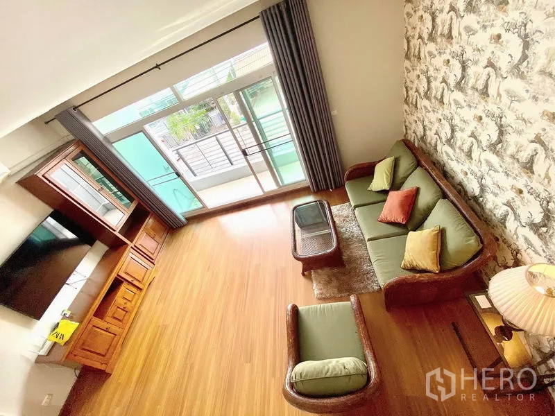 Townhouse for rent in Prawet, Bangkok - Upstairs family lounge with sofa set and wide sliding doors opening to a balcony.