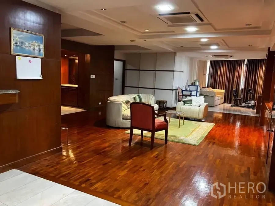 Condominium for rent or sale in Khlong Toei, Bangkok - Spacious open-plan living room with polished hardwood floors, recessed ceiling lights and lounge seating at President Park condominium.