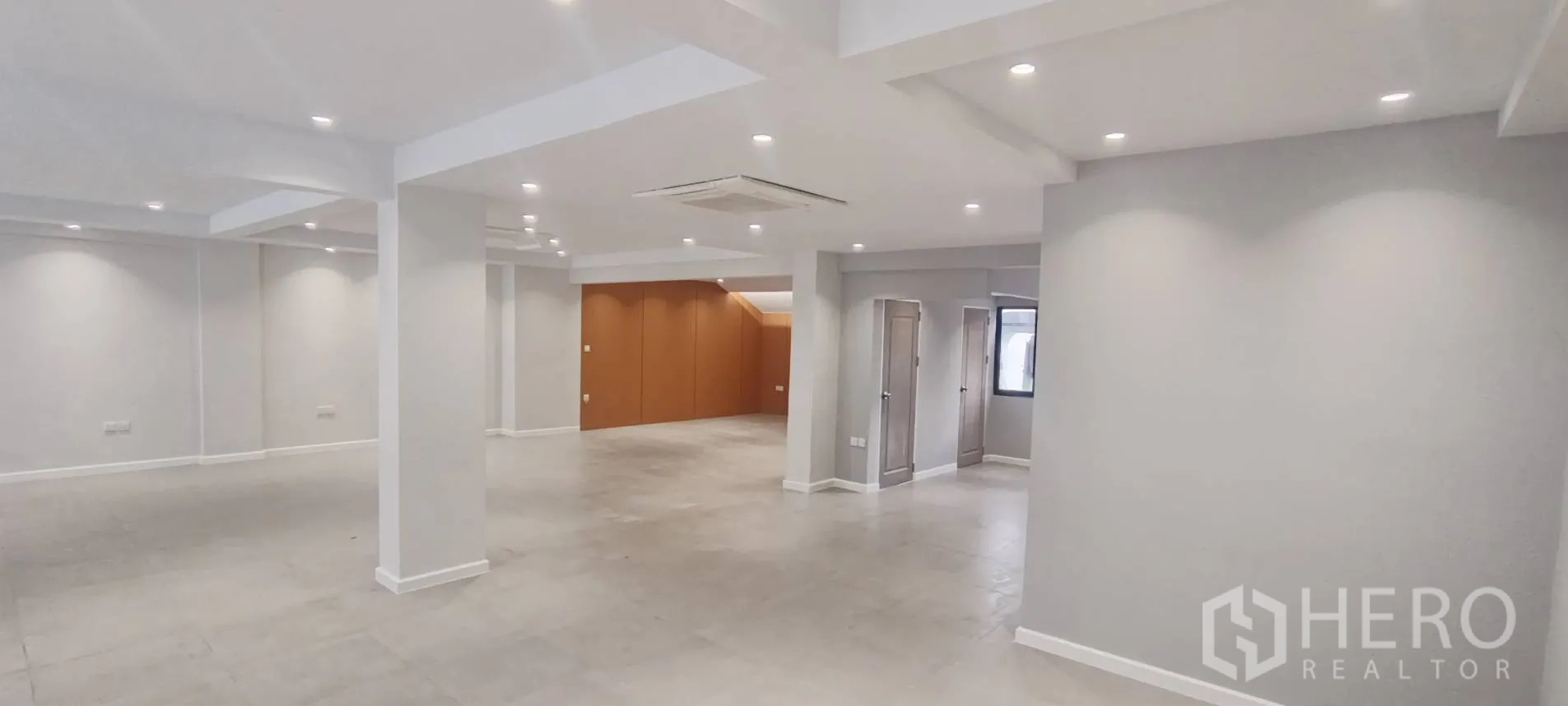 Office Space for rent in Watthana, Bangkok - Expansive open area with multiple columns and two restroom doorways.