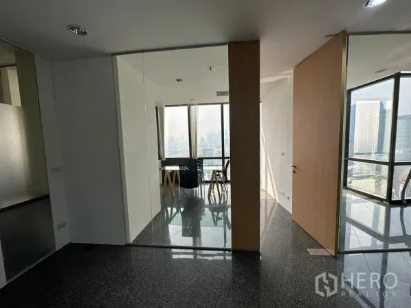 Office Space for rent - Entrance to a glass-partitioned meeting area with skyline views and glossy granite flooring.