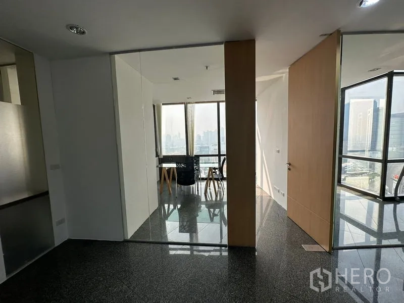 Office Space for rent - Entrance to a glass-partitioned meeting area with skyline views and glossy granite flooring.