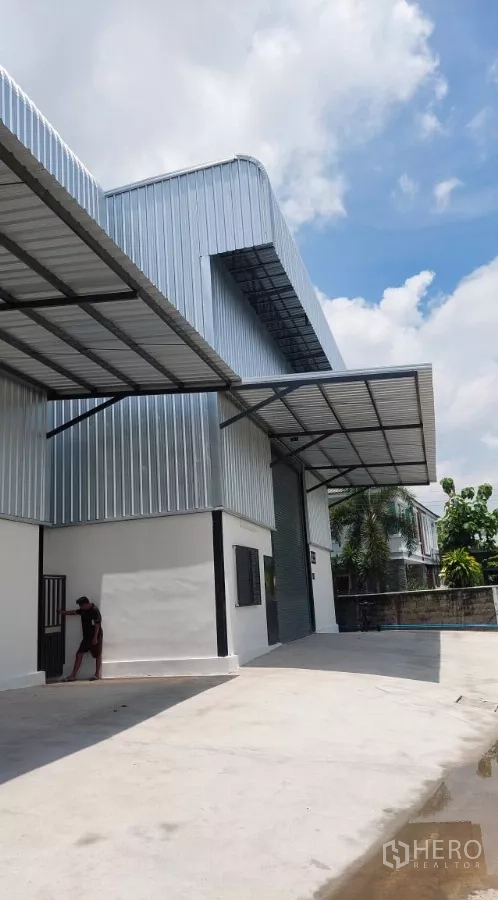 Warehouse for rent in Khlong Toei, Bangkok - Wide concrete yard in front of the warehouse with a protective awning for loading.