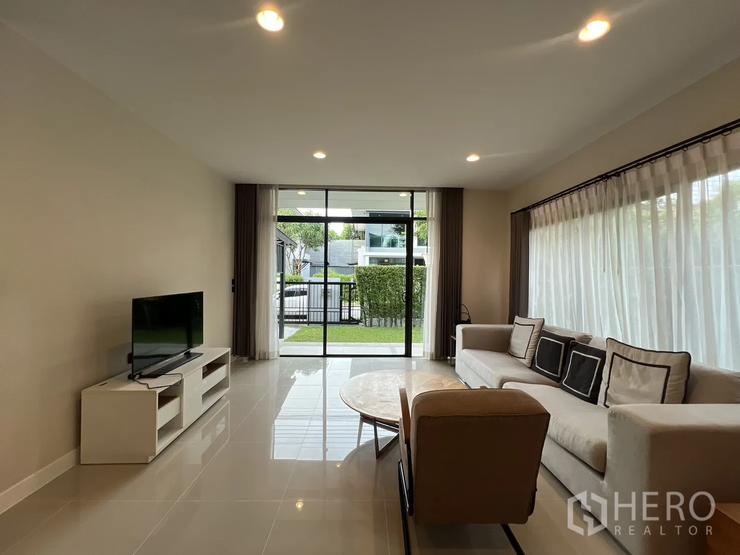 Detached House for rent in Bang Kapi, Bangkok - Bright lounge facing the garden with TV unit and sofa.