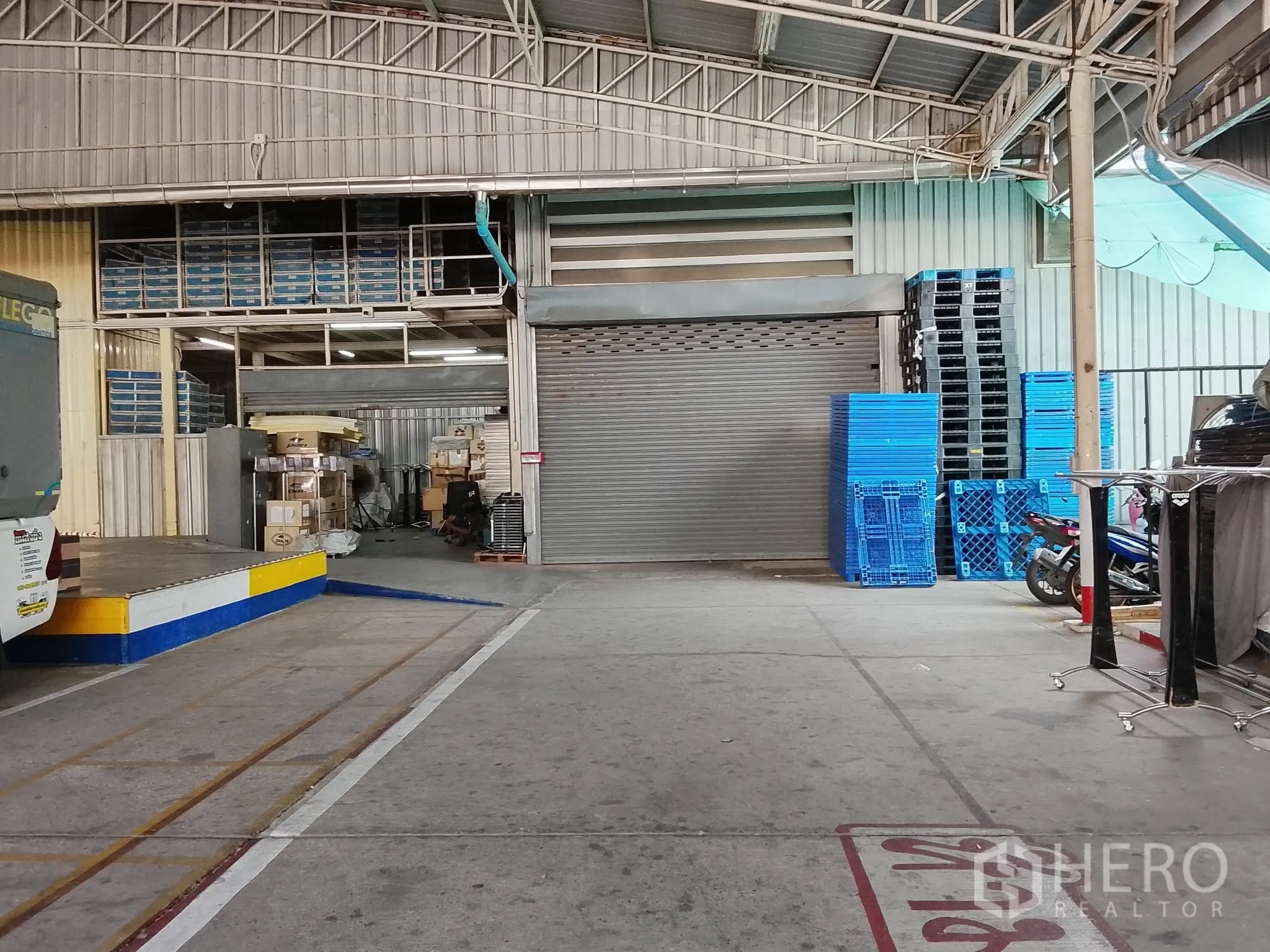 仓库 for rent in Bang Kho Laem, Bangkok - 单元外部带顶装卸区，设卷门与堆放的托盘。