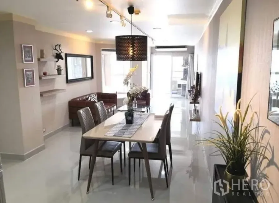 Condominium for rent in Khlong Toei, Bangkok - Long view from dining to living area with pendant lamp and bright balcony.