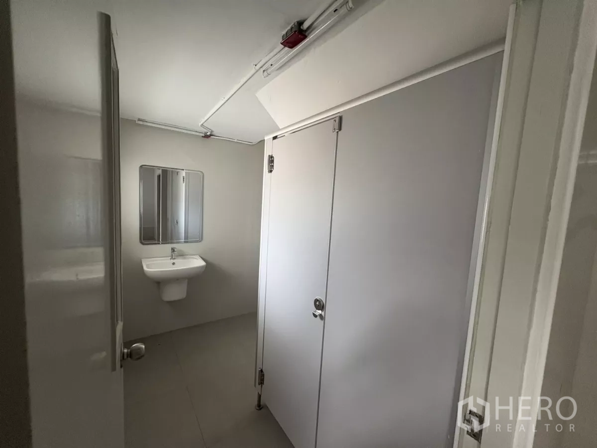 Factory for rent in Bang Phli, Samut Prakan - Restroom with cubicle stalls and wall-mounted sink.