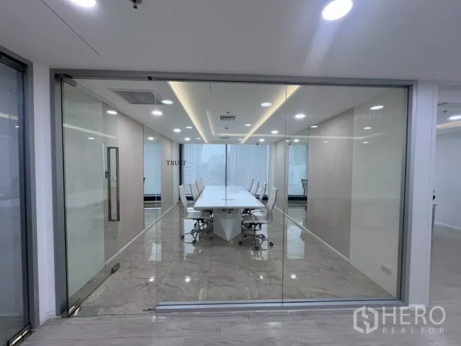 Office Space for rent in Din Daeng, Bangkok - Glass-walled boardroom with a long white conference table, marble floors and LED lighting, with city views beyond.