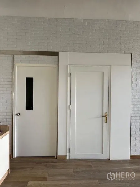 Retail Space for rent - Service doors to back rooms against a white brick wall with lower storage cabinets.